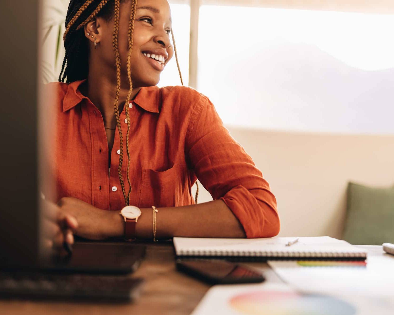 Female self-employed person smiling while sitting in front of her computer