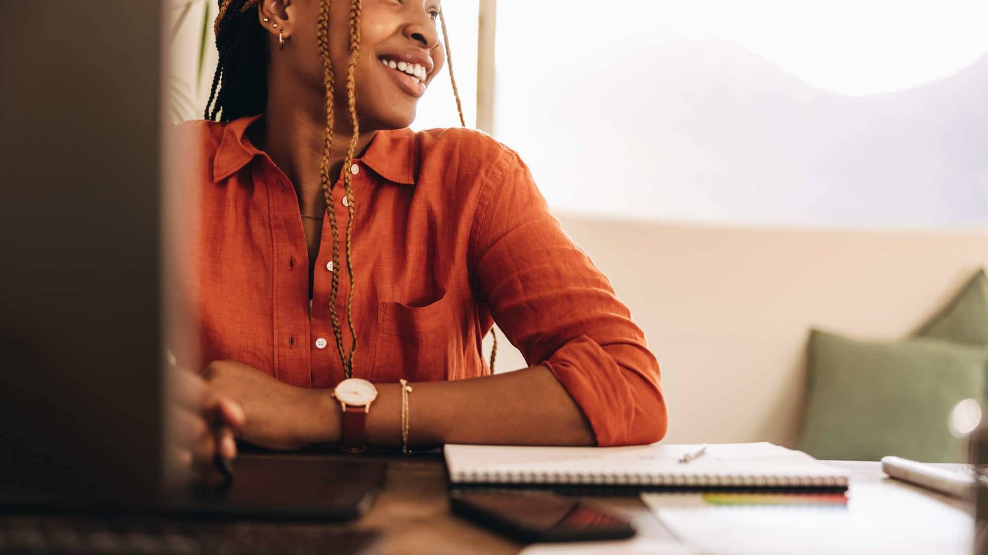 Female self-employed person smiling while sitting in front of her computer