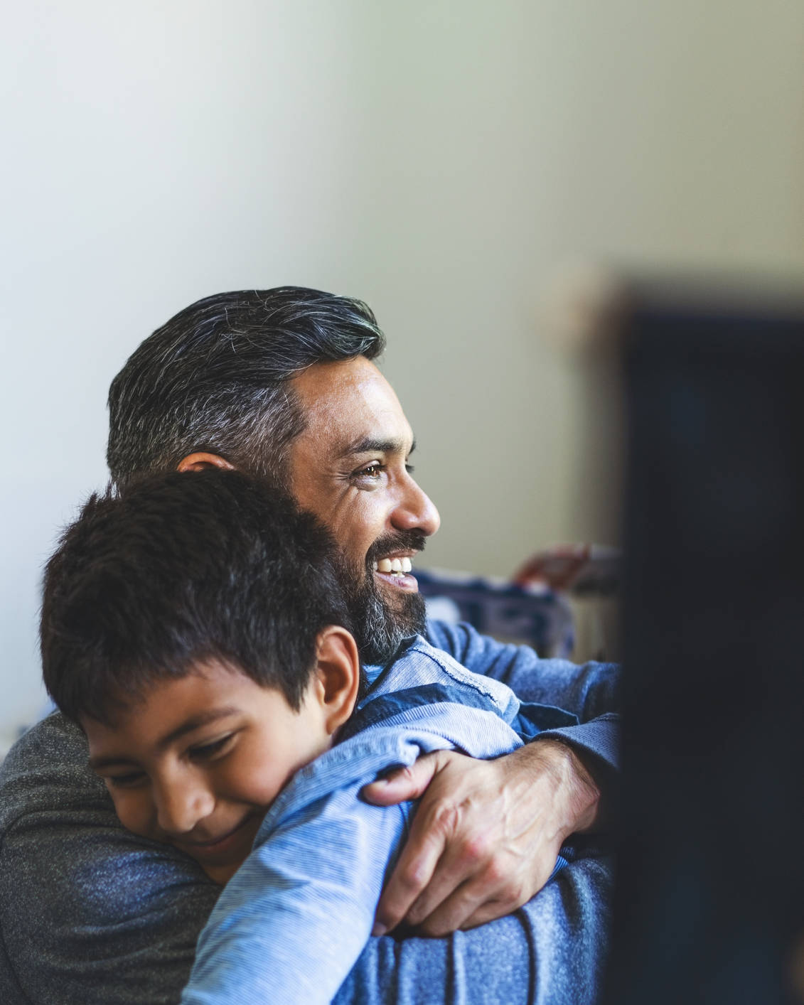 Smiling man embracing his son