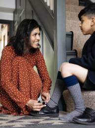 Mother helping son with shoes