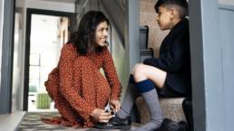 Mother helping son with shoes