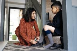 Mother helping son with shoes