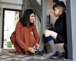 Mother helping son with shoes