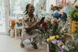 Florist using a tablet in a flower shop to review business finances before tax year end