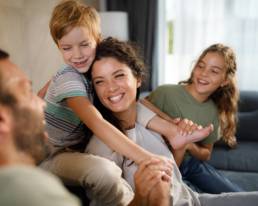 Parents and children sharing a happy moment at home, representing family financial security and long-term planning
