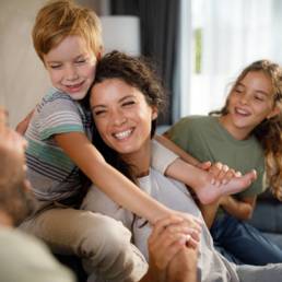 Parents and children sharing a happy moment at home, representing family financial security and long-term planning