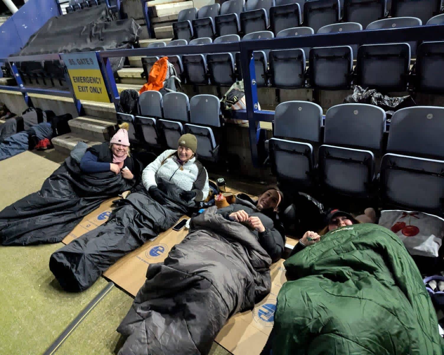 Amber River True Bearing colleagues in sleeping bags on cardboard inside Preston North End stadium during a charity sleep out.