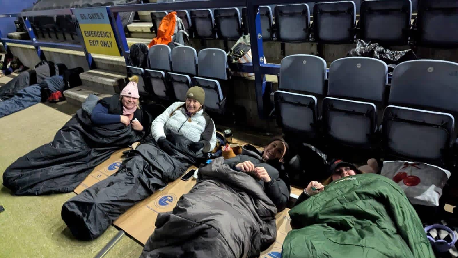 Amber River True Bearing colleagues in sleeping bags on cardboard inside Preston North End stadium during a charity sleep out.