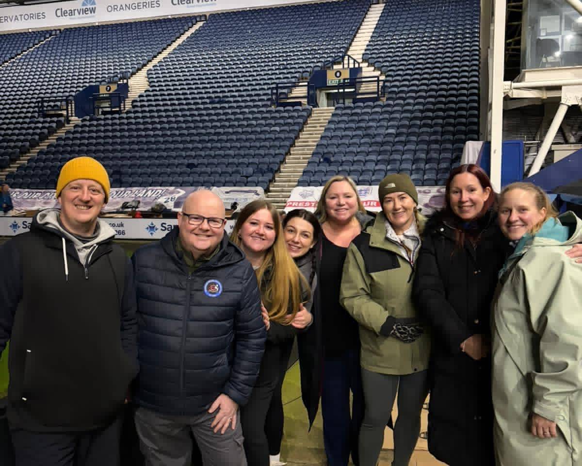 Amber River True Bearing colleagues in sleeping bags on cardboard inside Preston North End stadium during a charity sleep out.