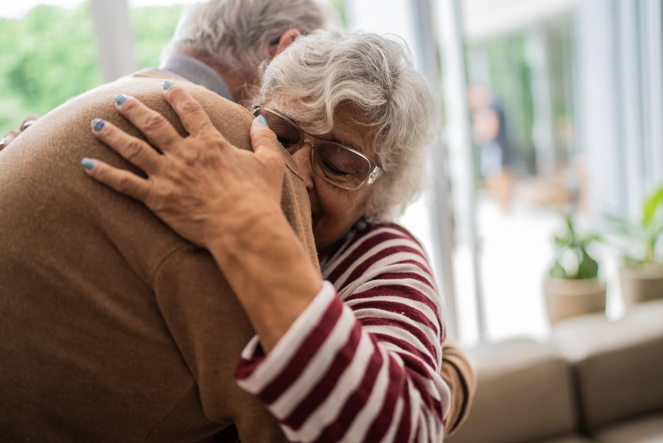 Older couple embracing at home, representing financial security and peace of mind