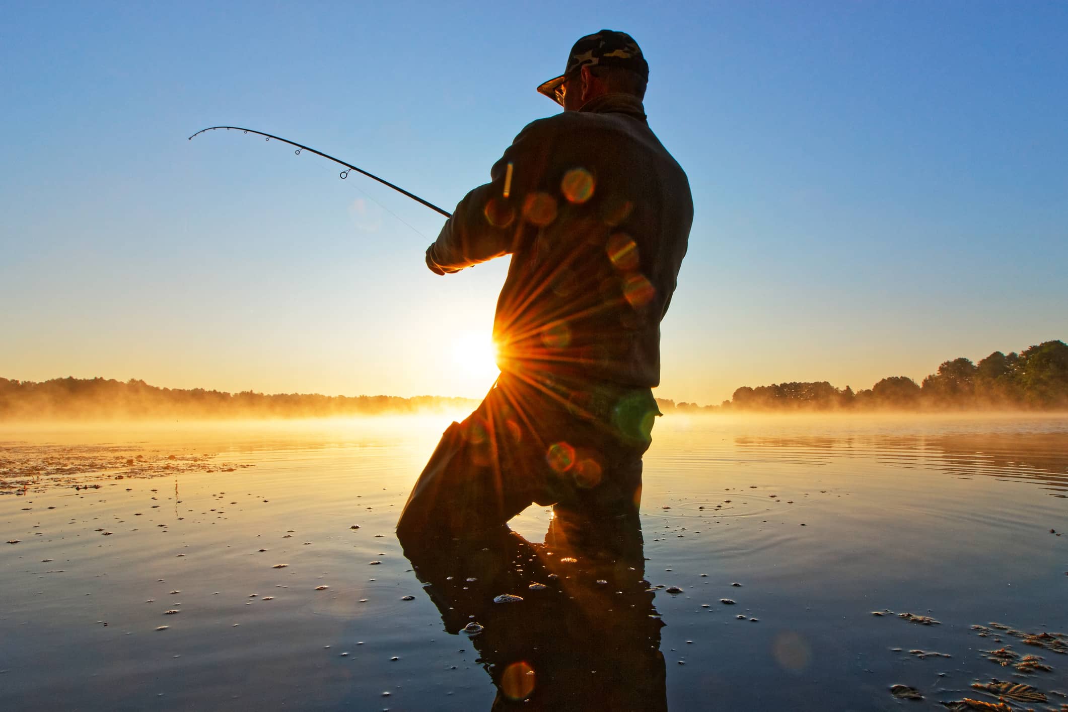 Person fishing at sunrise, representing careful financial planning before selling a business.