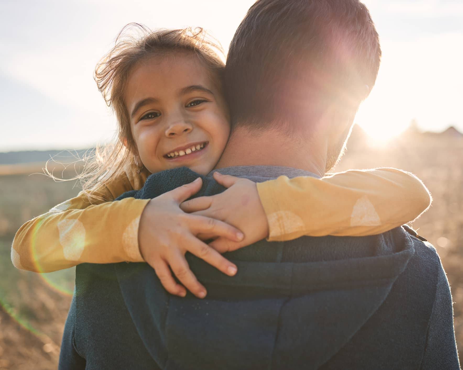 Young child hugging a parent, representing financial security and long-term family financial planning during uncertain times.