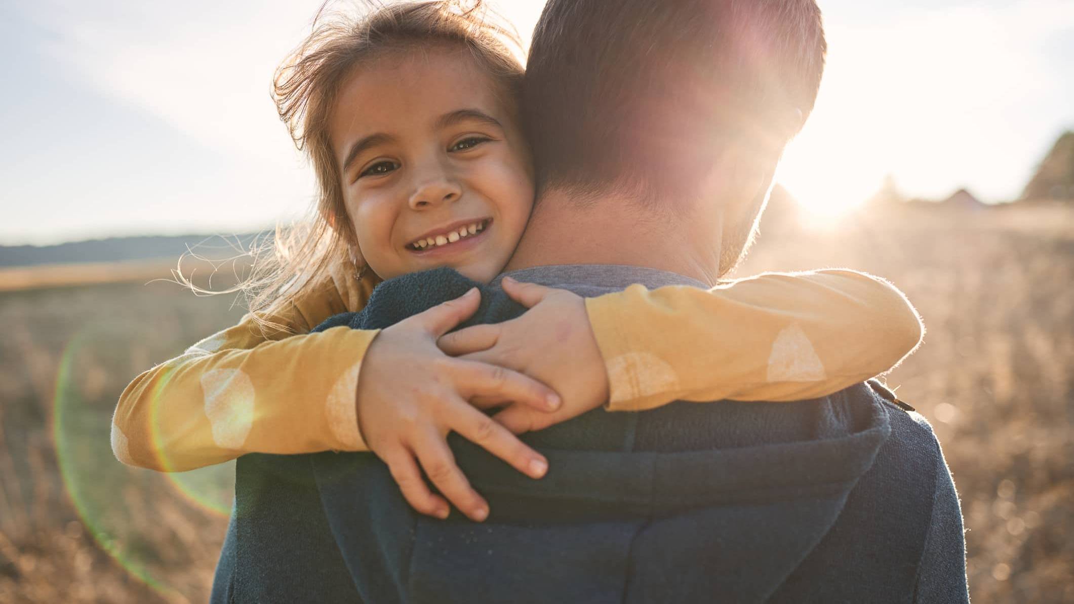 Young child hugging a parent, representing financial security and long-term family financial planning during uncertain times.