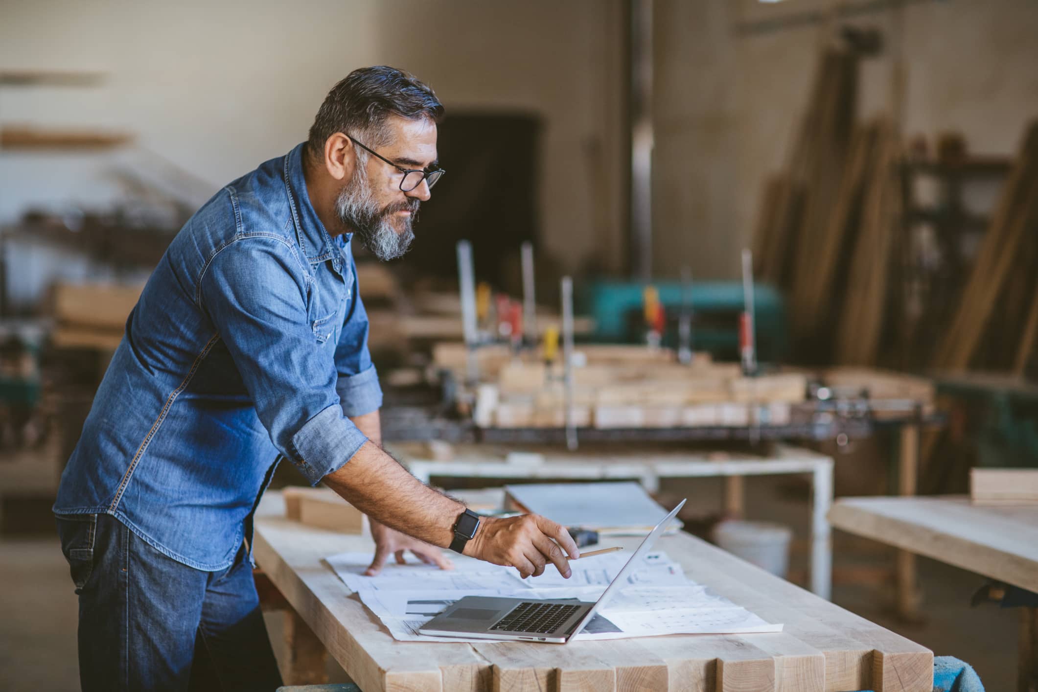 Business owner reviewing business plans on a laptop while building personal wealth alongside business growth