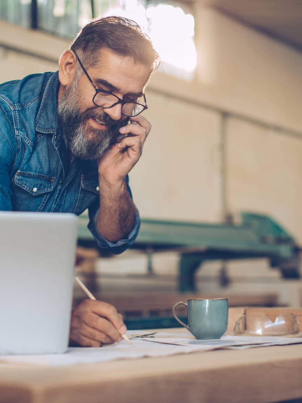 Business owner speaking on the phone while planning investments and long-term personal wealth outside the business