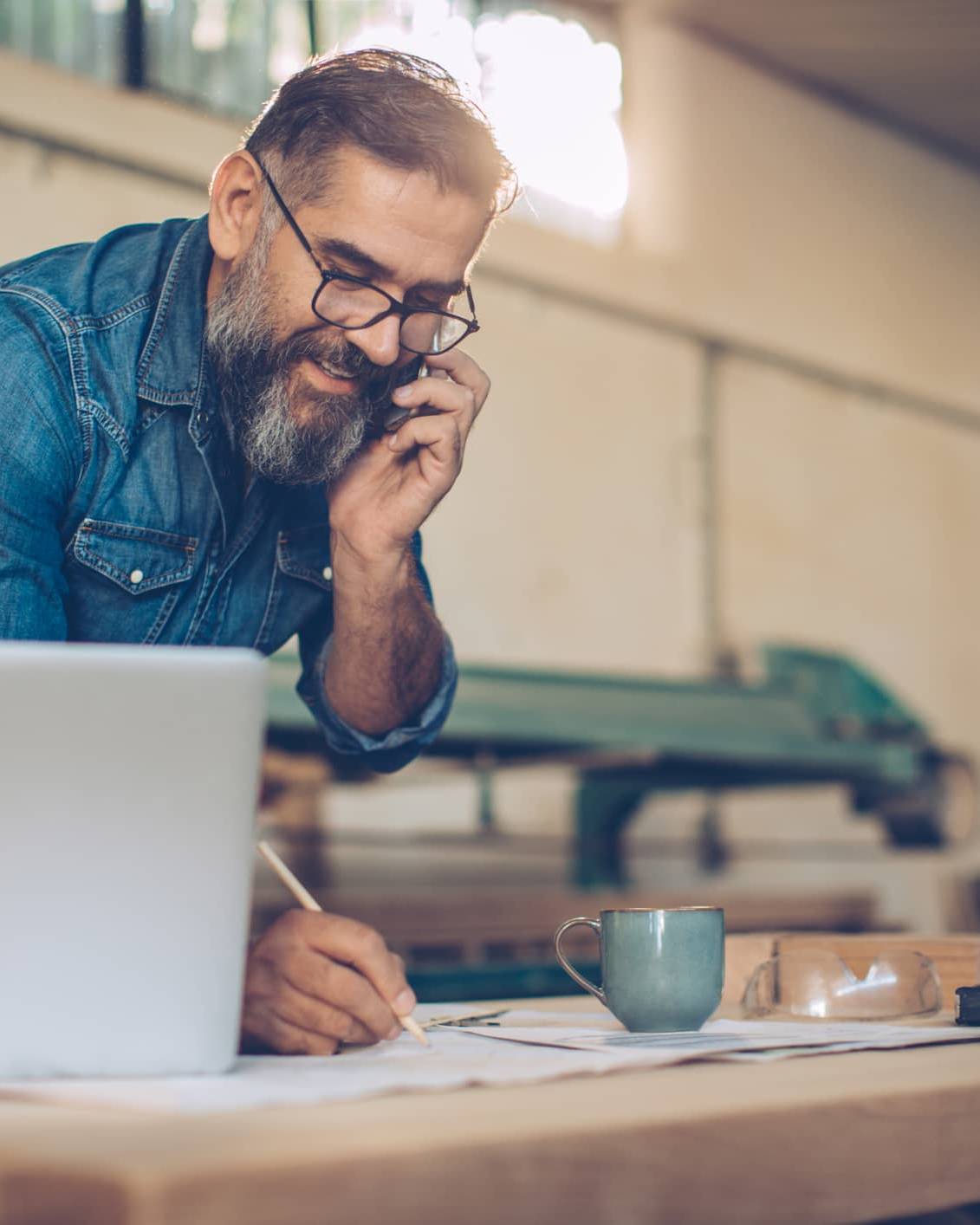 Business owner speaking on the phone while planning investments and long-term personal wealth outside the business