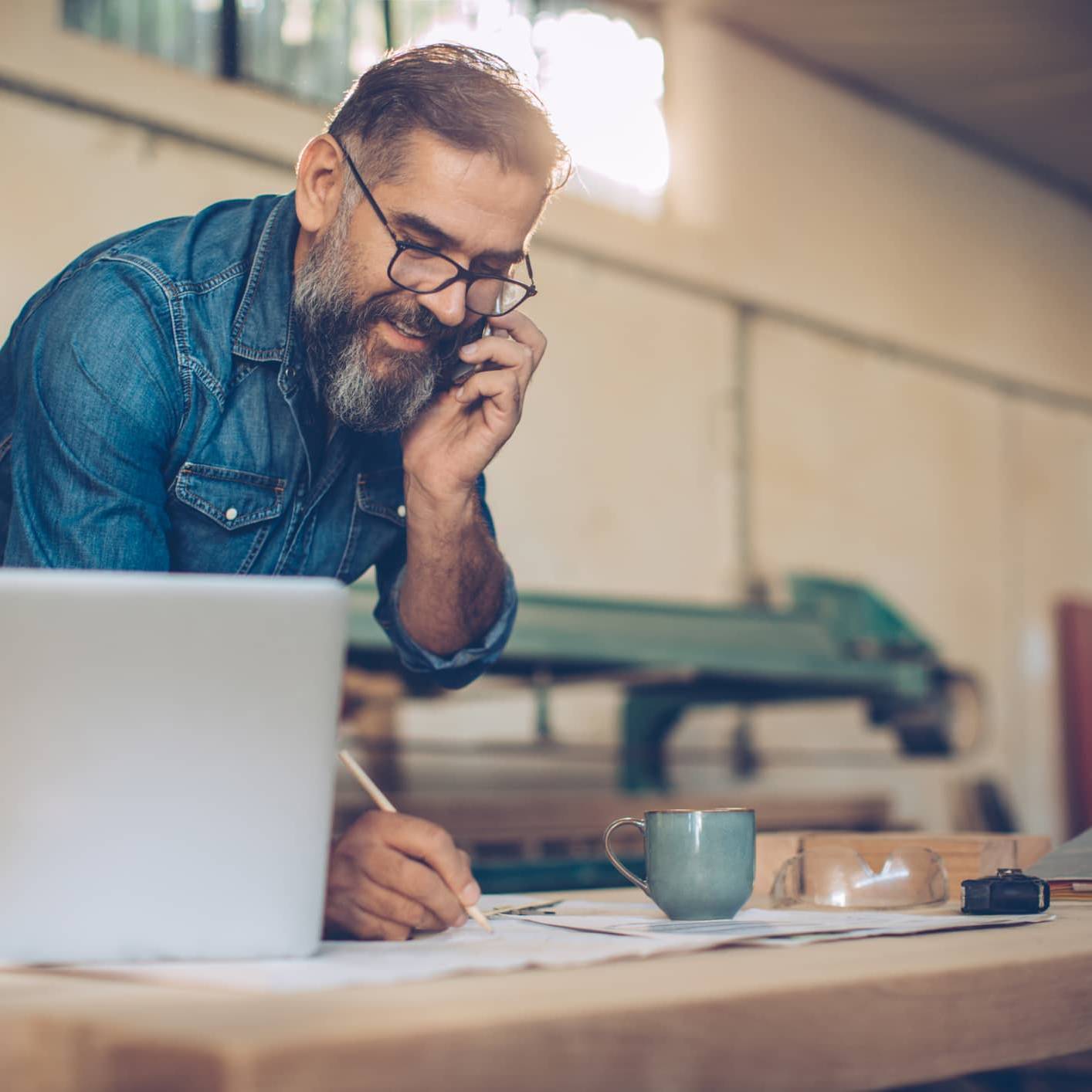 Business owner speaking on the phone while planning investments and long-term personal wealth outside the business
