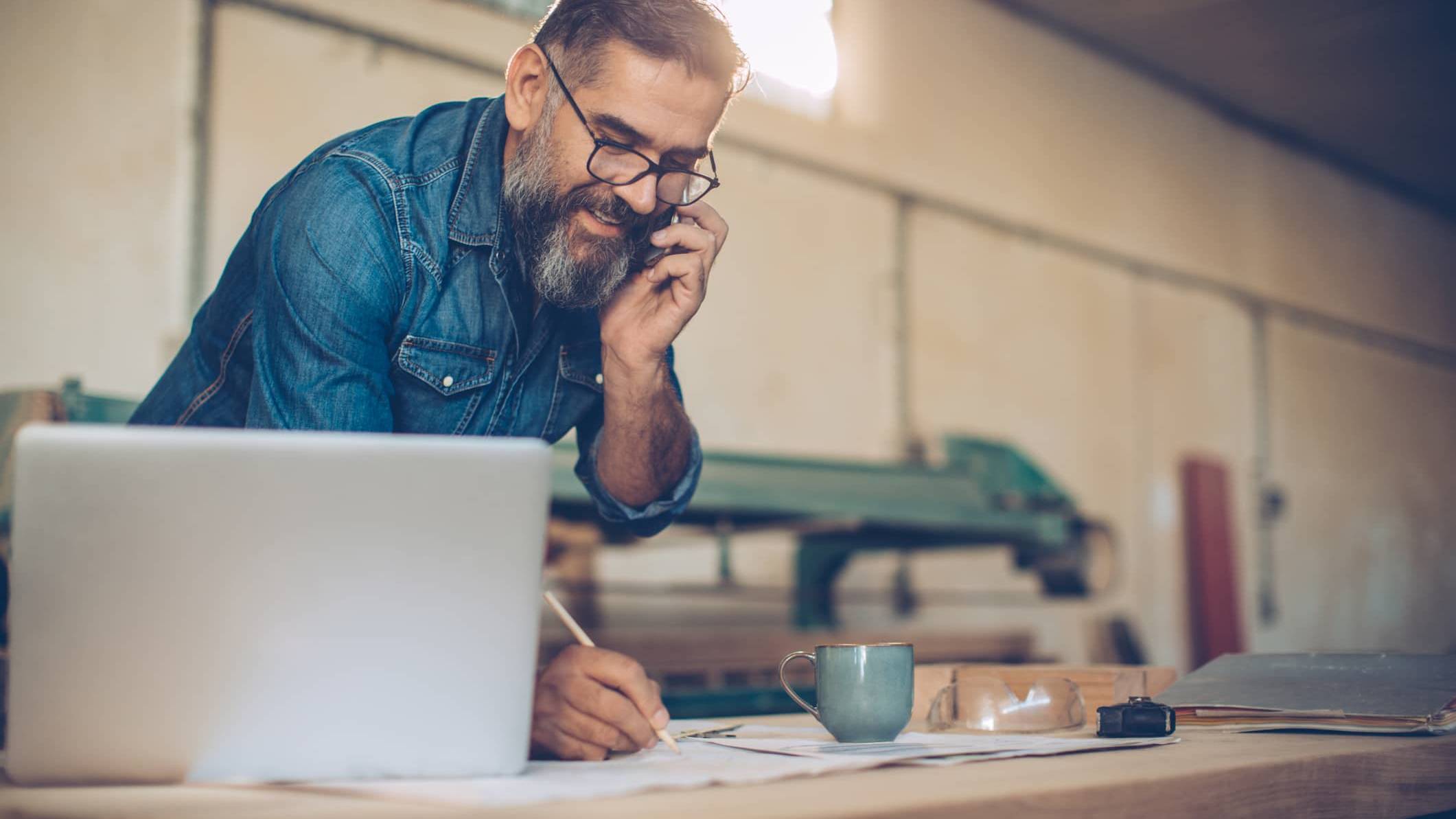 Business owner speaking on the phone while planning investments and long-term personal wealth outside the business