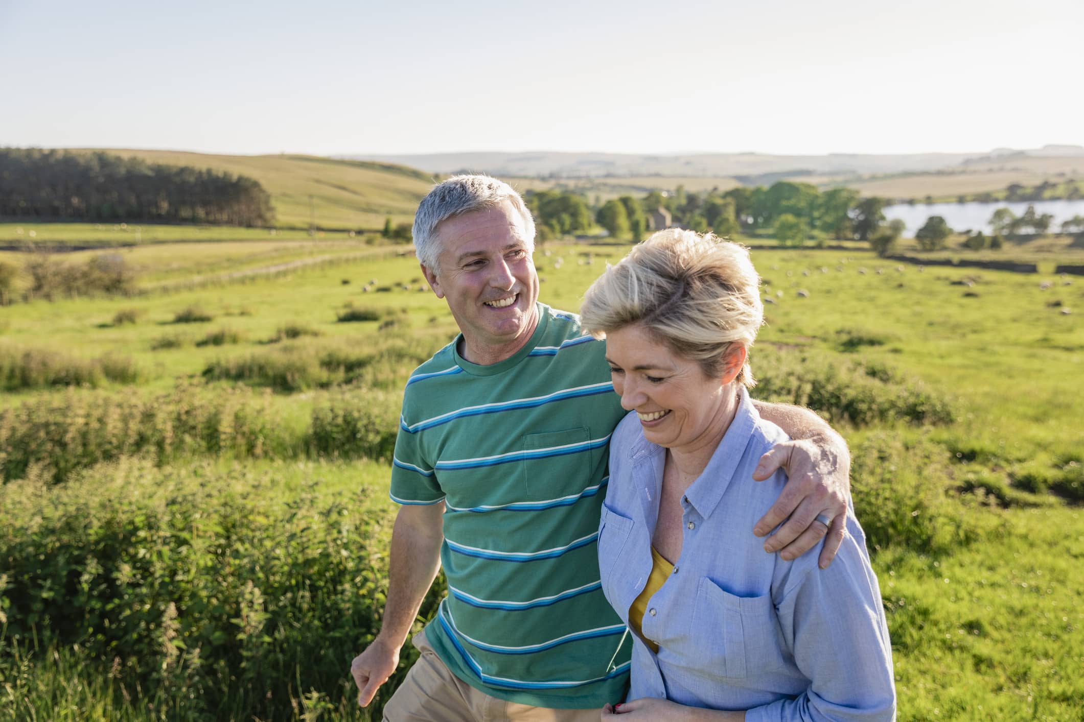 Couple walking together in the countryside, representing reviewing pension planning and estate planning after the proposed Inheritance Tax changes.