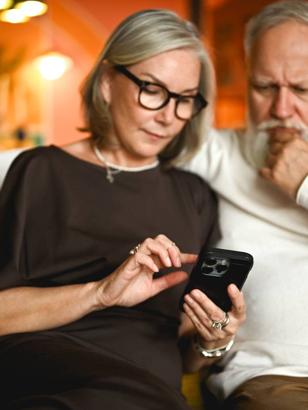 Older couple looking at a smartphone while checking for signs of a potential financial scam