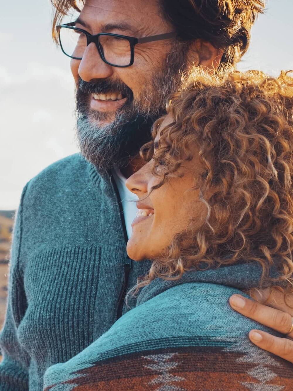 Smiling couple embracing while enjoying time outdoors together