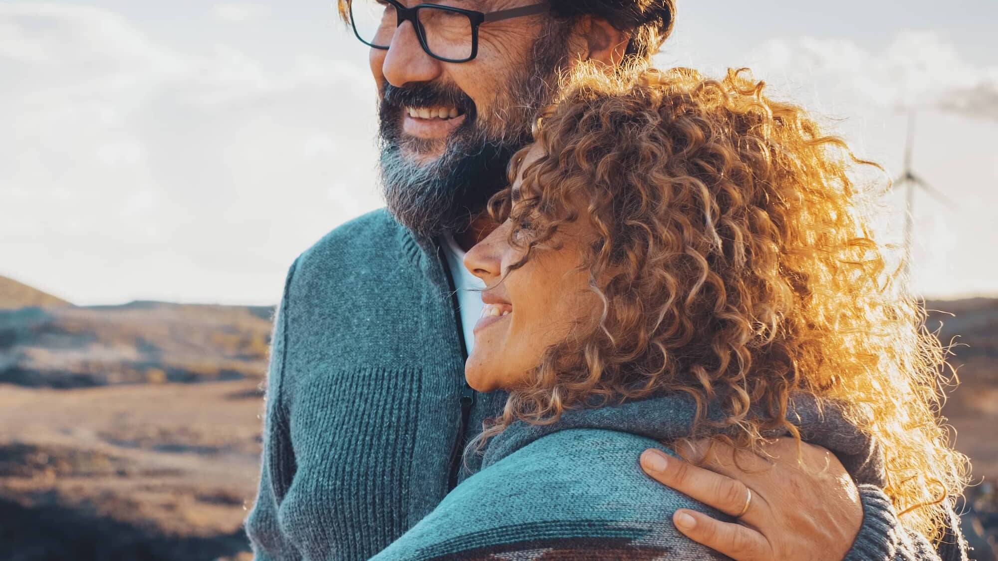 Smiling couple embracing while enjoying time outdoors together