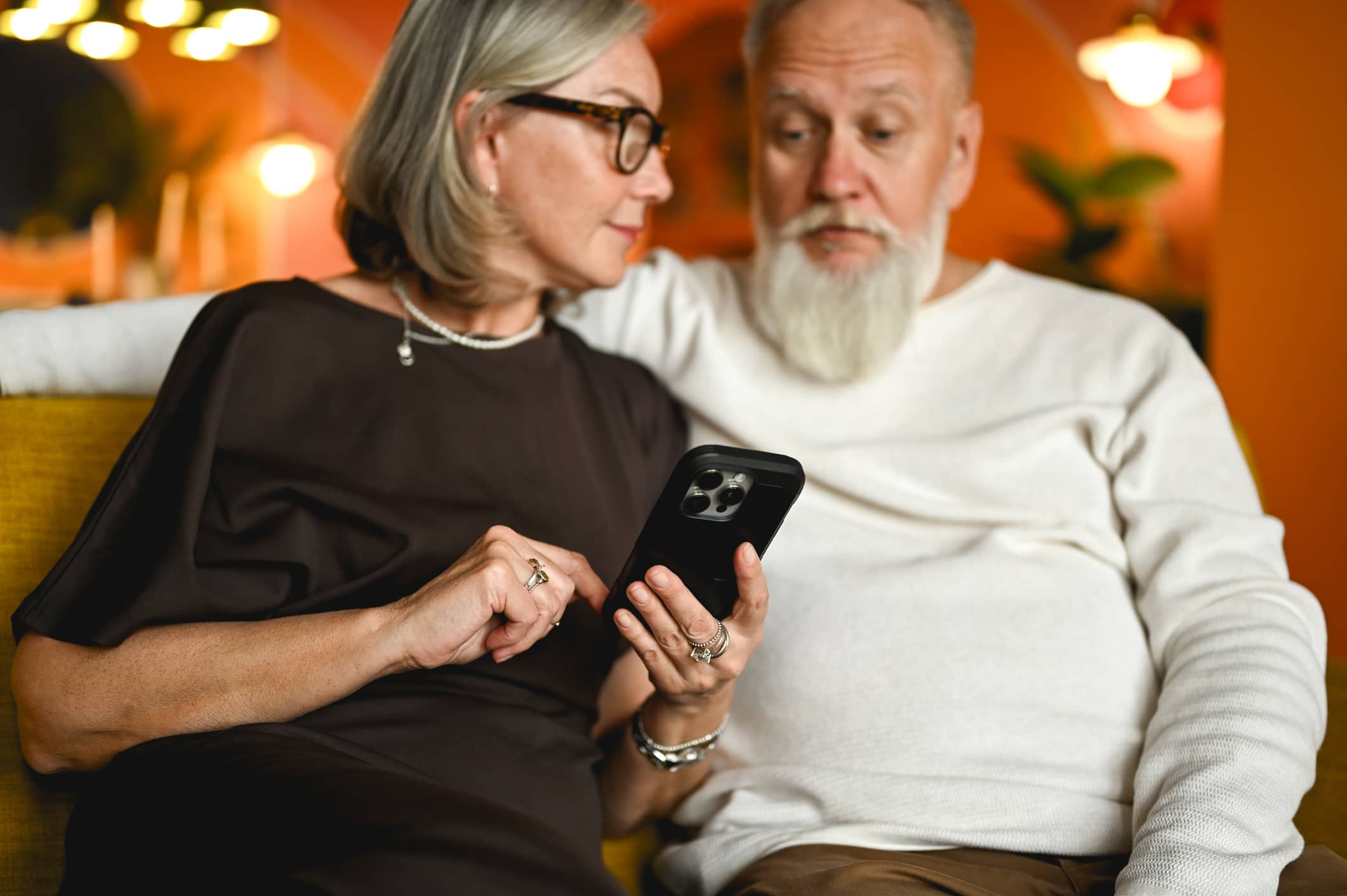 Older couple looking concerned while reviewing a suspicious message on a smartphone