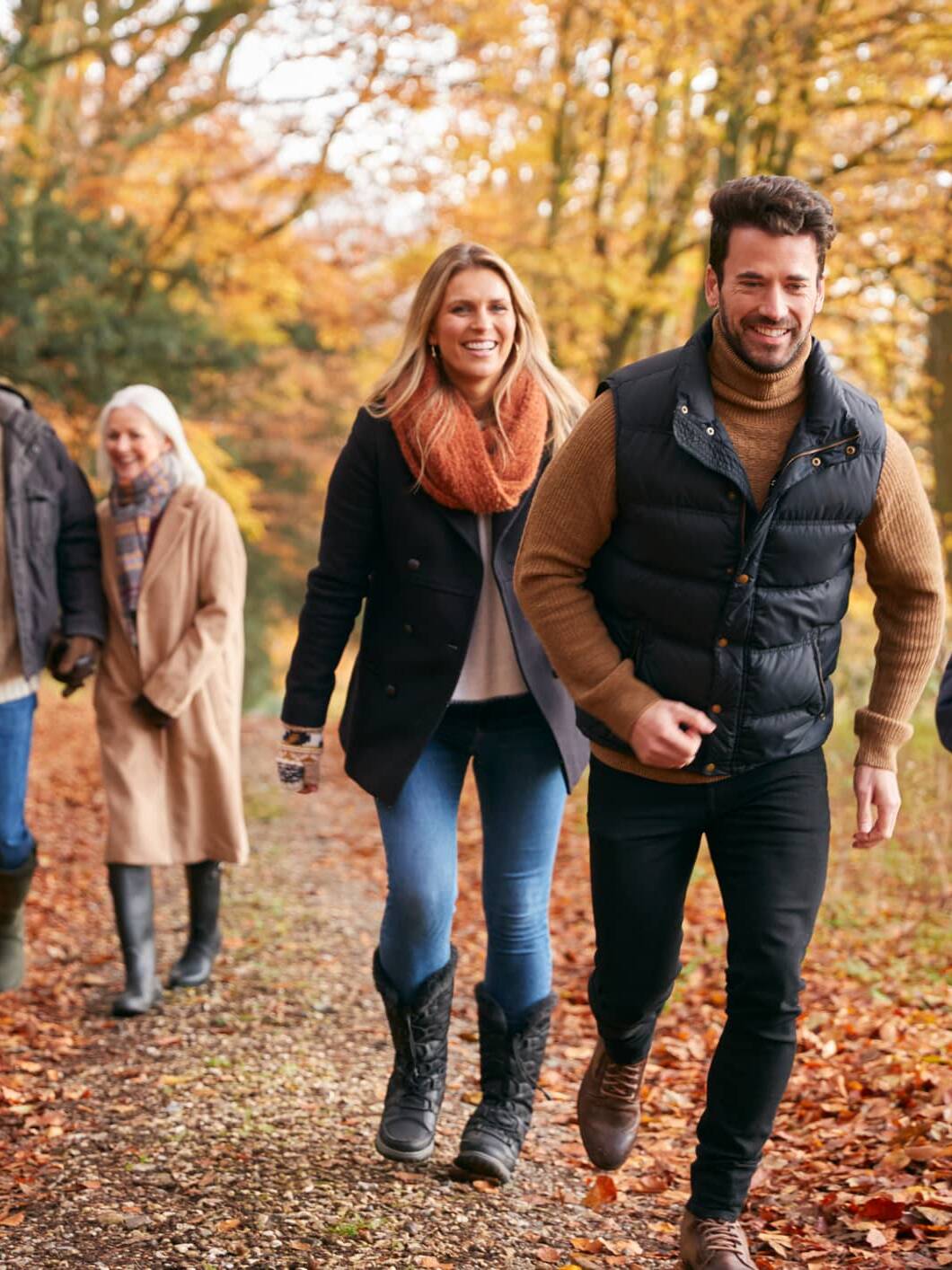 Three generations of a family enjoying an autumn walk together in the countryside.