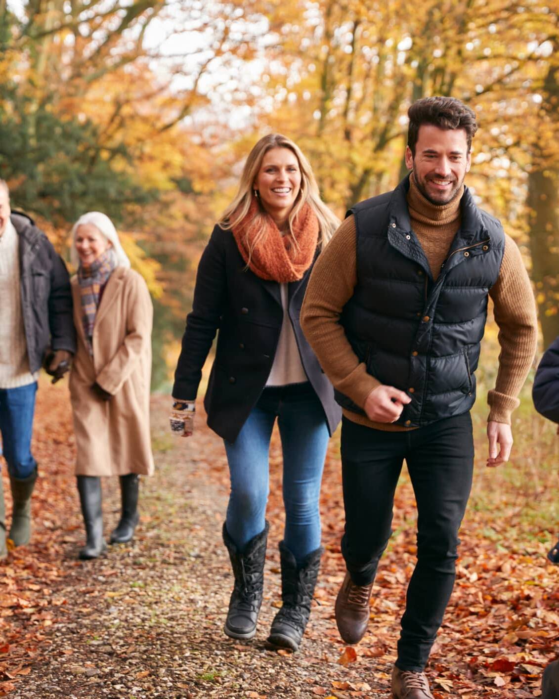 Three generations of a family enjoying an autumn walk together in the countryside.