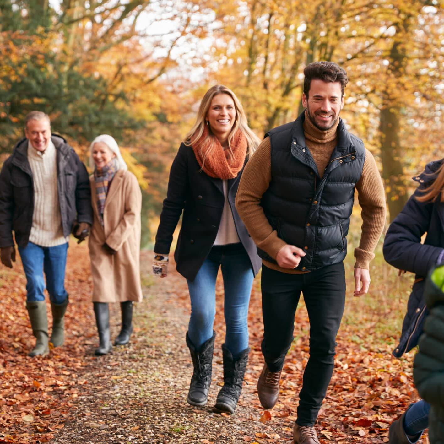 Three generations of a family enjoying an autumn walk together in the countryside.