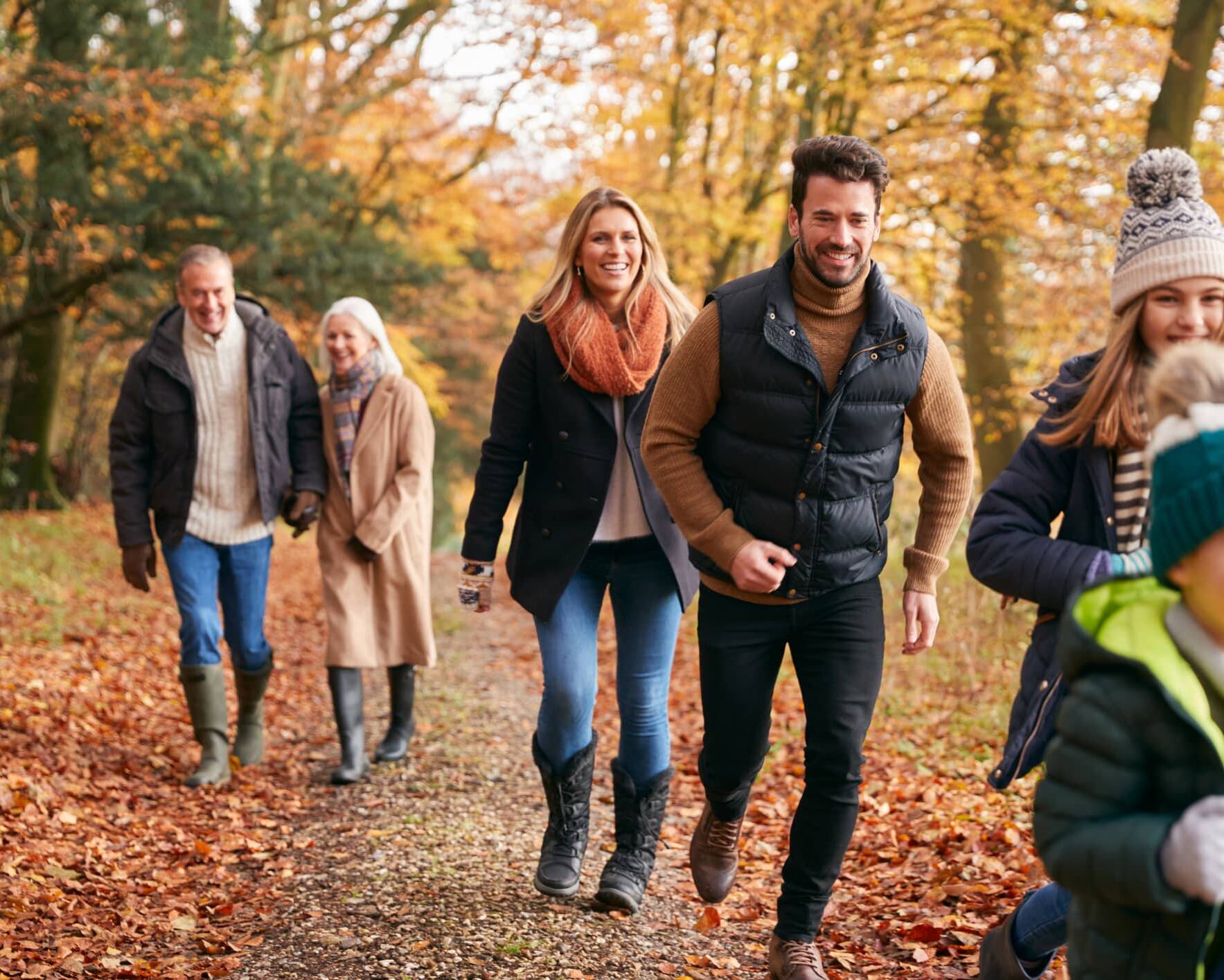 Three generations of a family enjoying an autumn walk together in the countryside.