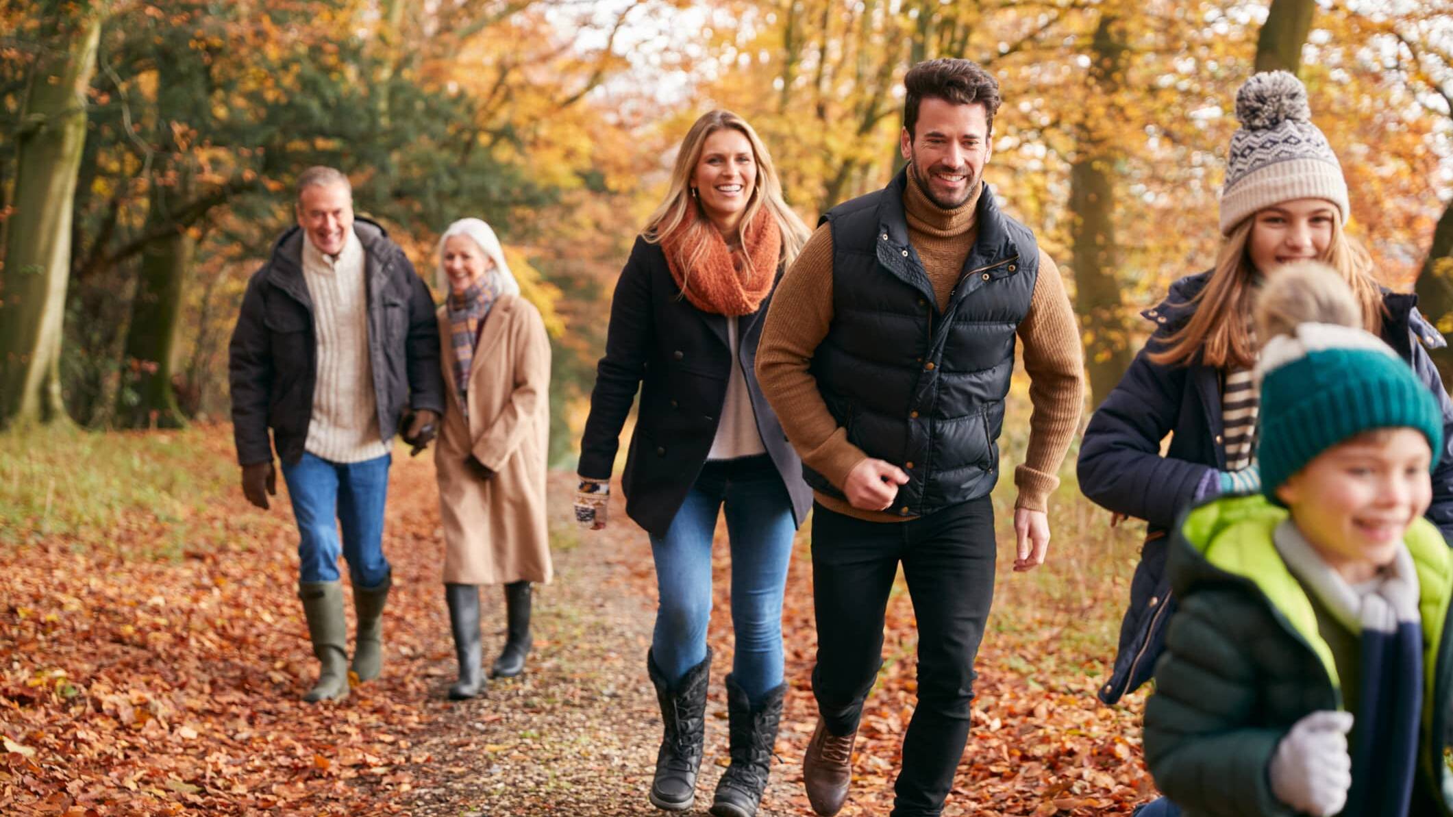 Three generations of a family enjoying an autumn walk together in the countryside.